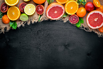 Fresh citrus fruits. Lemon orange, tangerine, lime. On a black background Wooden. Top view.