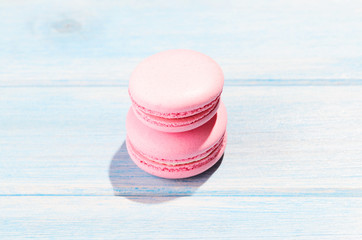 Two pink macaroons on blue wooden table