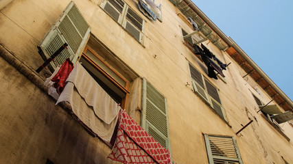 Exterior of buildings in Europe with clothes hanging from window. Nice, France.