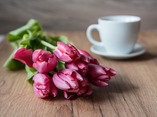  coffee cup with tulips on wooden back ground