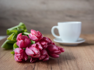  coffee cup with tulips on wooden back ground