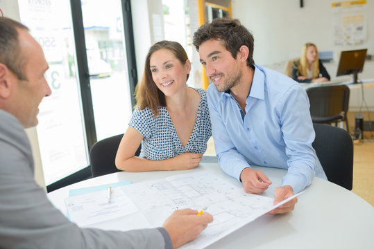 Architect drawing up plans with young couple