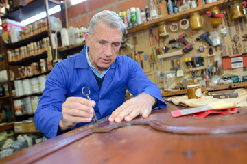 older man restoring a table
