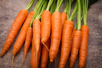 Fresh and sweet carrot on a grey wooden table.