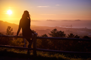 Mujer joven al atardecer contemplando las Islas Cíes en Vigo