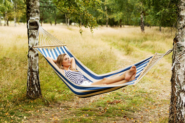 Young blonde woman resting on hammock