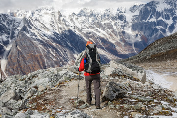 Trekker goes down fron Larke La pass on Manaslu circuit trek in Nepal