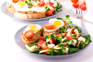 Salad with strawberry, spinach and goat cheese.  Bruschettes