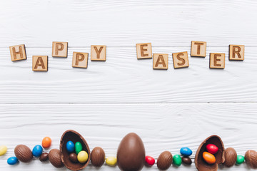 Chocolate Easter eggs on white wooden background.