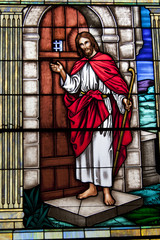 Gorgeous stained glass window of Jesus Christ knocking on door.