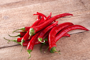 few spicy red peppers on an old board