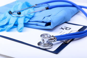 Medical stethoscope, Gloves, RX prescription on blue doctor uniform closeup. Medical tools and instruments shop, therapeutist workspace, physical, blood pressure measurement concept