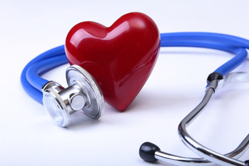 Medical stethoscope and red heart isolated on white