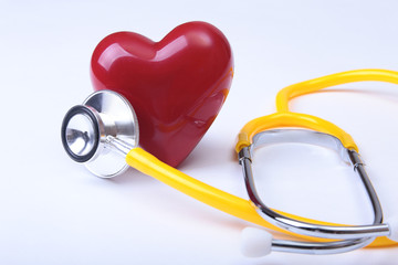 Medical stethoscope and red heart isolated on white