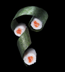 Flying sushi with salmon on a black background. 3 roles