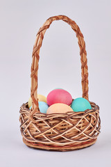 Fototapeta na wymiar Basket with colorful eggs isolated. Painted chicken eggs. Easter breakfast idea.