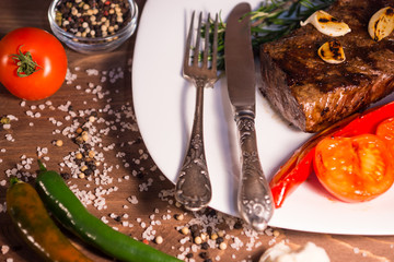 Вкусный стейк из говядины на белой тарелке