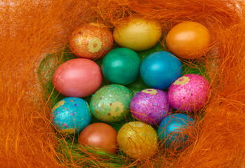 Happy Easter. Colorful Easter eggs in a basket on the artificial grass