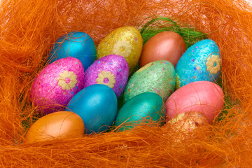 Happy Easter. Colorful Easter eggs in a basket on the artificial grass