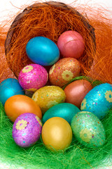 Happy Easter. Colorful Easter eggs in a basket on the artificial grass