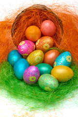 Happy Easter. Colorful Easter eggs in a basket on the artificial grass