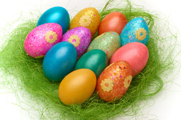 Happy Easter. Colorful Easter eggs in a basket on the artificial grass