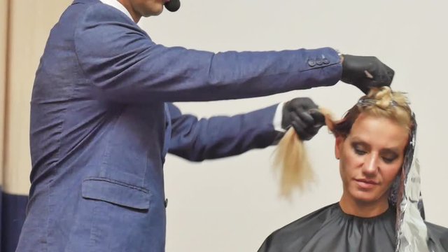 Hairdresser In Action. Barber and customers. hairstyle models for white hair. Blonde in the cabin. Work in the cabin. Barber shears white hair model client. close-up.