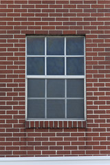 Single window on red brick wall.