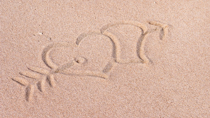 Fototapeta na wymiar Two Hearts and arrow, We heart it, Drawn on Sand on the Beach, Bali, Indonesia