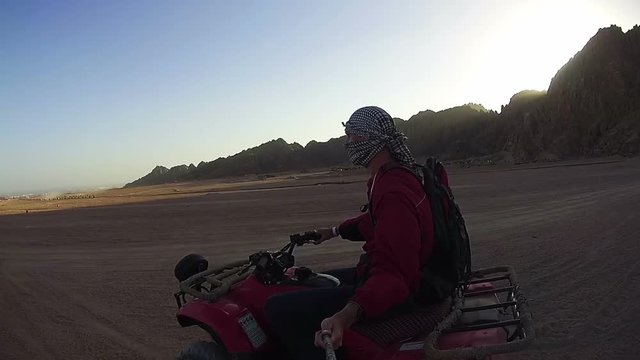 Riding on Quad Bikes in the Desert of Egypt. Driving ATVs. Adventures of desert off-road on ATVs. First-person view on action camera.