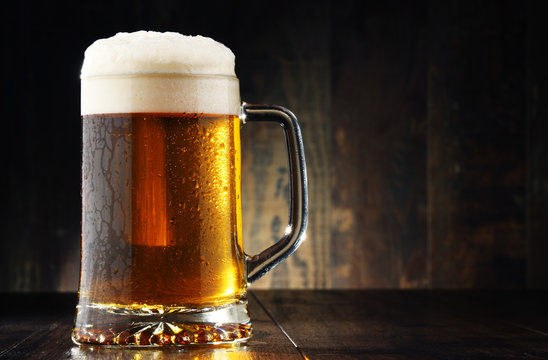 Composition with glass of beer on wooden background