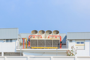 Industrial cooling towers or air cooled chillers on new building factory rooftop with blue sky...