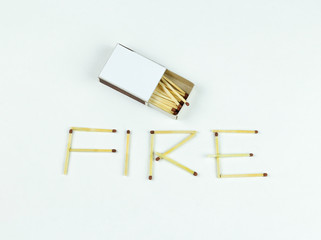 Closeup outdoor white boxes of matches. Scattered matches. Matches laid out the word Fire. Isolated on white background