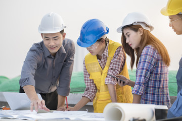 Asian engineers were consulted together and plan in construction site