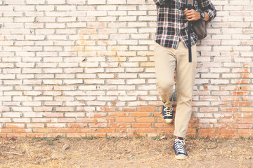 Hipster feet a man and jeans sneaker in old wall and relax time on holiday. selective and soft focus color of vintage tone