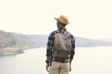 Happy Asian hipster man backpack in nature background, Relax time on holiday concept travel , color of vintage tone and soft focus