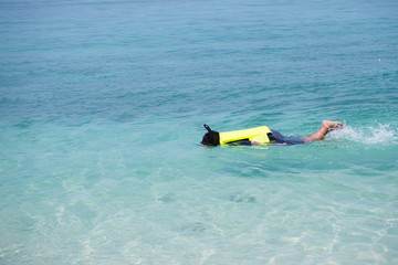 Asian man diving underwater on summer beach.