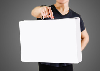 Man in a black shirt holds a white box with a handle. Packing box for laptop. Isolated on white background