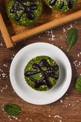 Fresh muffins with spinach, desiccated coconut and chocolate glaze, delicious healthy dessert