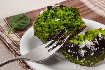 Fresh muffins with spinach, desiccated coconut and chocolate glaze, delicious healthy dessert