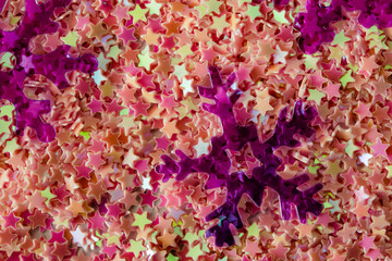 Abstract background of brightly colored plastic stars and snowflakes