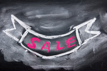Grunge ribbon draw by white and red chalk with sale wording on black board background