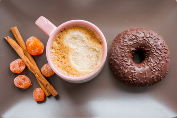 dry kumquat .dried fruits. chokolade donut. a Cup of coffee. Part of Breakfast