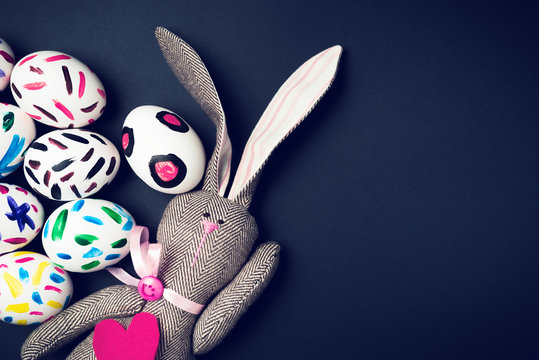 Easter bunny on a black background. Rabbit. Easter ideas. Easter eggs. Space for text. Image in trendy toning.