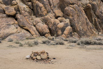 Small circle of stones forms a firepit in a boulder canyon inside California's southern Mojave desert.