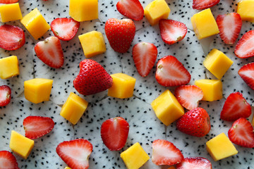 Ripe and fresh mango, dragon fruit and strawberries close up.