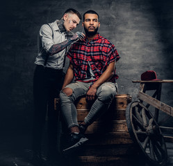 Male barber cutting the beard to Black stylish man.