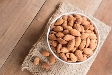 Almond in white bowl on wooden table