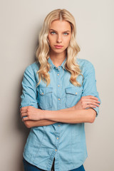 casual blonde woman standing with hands crossed