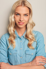 closeup of a smiling young casual woman with hands crossed